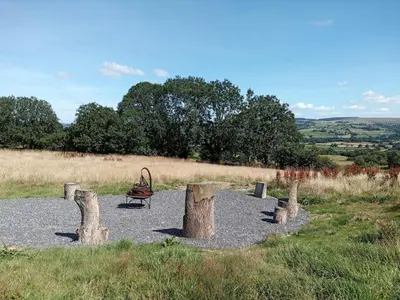 a park with a playground with logs and a bench at 1 Bed in Llanybydder oc-81354 in Llanwenog