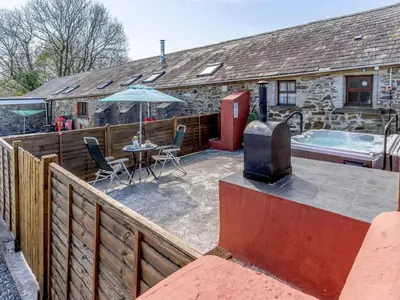 a patio with a tv and a table and a tub at 1 Bed in Llanybydder oc-81354 in Llanwenog