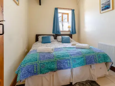 a bedroom with a large bed with blue curtains at 1 Bed in Llanybydder oc-81354 in Llanwenog