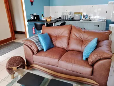 a brown leather couch with blue pillows in a kitchen at 1 Bed in Llanybydder oc-81354 in Llanwenog