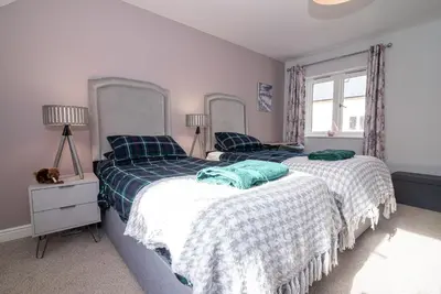 a bedroom with two beds and a window at Elegant Ludlow Haven: 4Bed Ultimate Tranquility in Ludlow