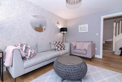 a living room with a couch and a mirror at Elegant Ludlow Haven: 4Bed Ultimate Tranquility in Ludlow