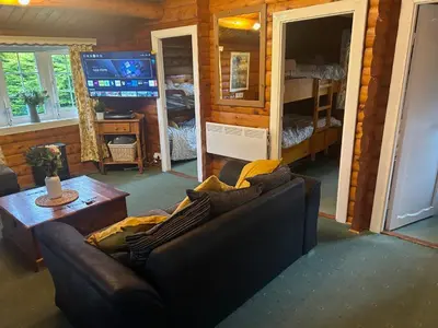 a living room with a couch and a tv at Cosy Log Cabin Snowdonia Eryri in Trawsfynydd