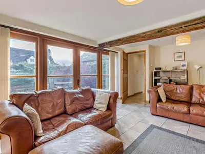 a living room with brown leather furniture and windows at 2 Bed in Shrewsbury oc-47795 in Ryton