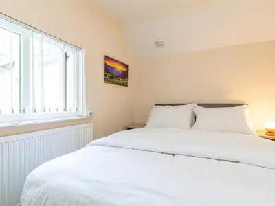 a bedroom with a large white bed and a window at 4 Bed in Bala oc-75288 in Llandderfel