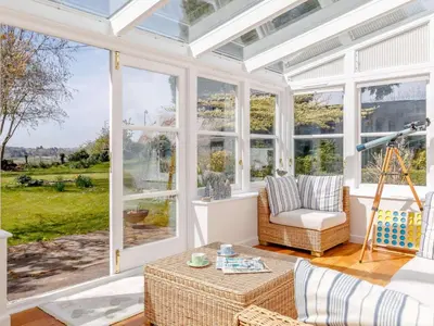 a conservatory with windows and a couch and a table at 3 Bed in Brecon oc-bn331 in Cathedine