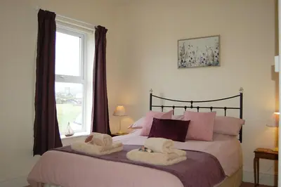 a bedroom with a large bed with towels on it at Cadair View Family Holiday Home in Tywyn
