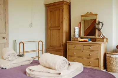 a bedroom with a bed with a dresser and a mirror at Cadair View Family Holiday Home in Tywyn