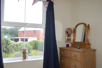 a window in a room with a dresser and a mirror at Cadair View Family Holiday Home in Tywyn