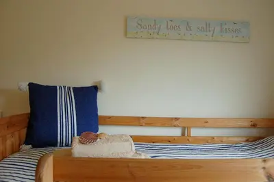 a bedroom with a wooden bed with a sign on the wall at Cadair View Family Holiday Home in Tywyn