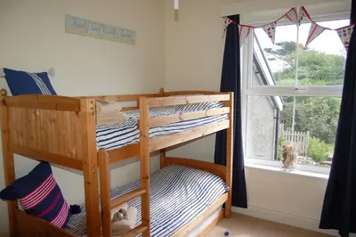 a bedroom with two bunk beds and a window at Cadair View Family Holiday Home in Tywyn