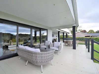 an outdoor deck with chairs and tables and windows at 4 Bed in Oswestry oc-74110 in Kinnerley
