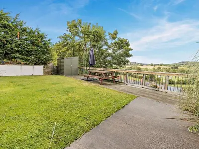 a backyard with a picnic table and an umbrella at 2 Bed in Corwen oc-77351 in Corwen