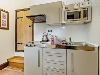 a small kitchen with a sink and a microwave at 2 Bed in Corwen oc-77351 in Corwen