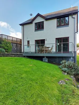 a large white house with a green lawn in front of it at Caer Dderwen Oak Field family home in Dolgellau in Dolgellau