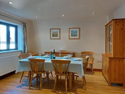 a dining room with a blue table and chairs at Caer Dderwen Oak Field family home in Dolgellau in Dolgellau