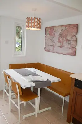 a dining room with a white table and chairs at Hafan Y Talgarth bungalow at Plas Talgarth resort in Pennal