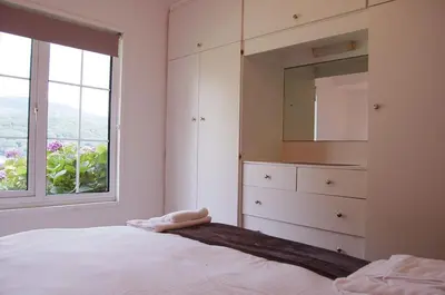 a bedroom with a bed and a dresser and a window at Hafan Y Talgarth bungalow at Plas Talgarth resort in Pennal