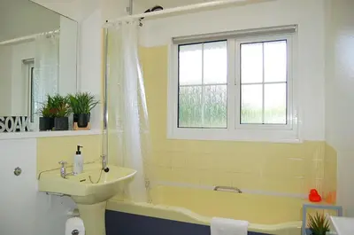 a bathroom with a sink and a tub and a window at Hafan Y Talgarth bungalow at Plas Talgarth resort in Pennal