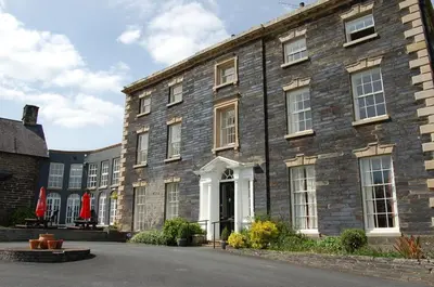 a large brick building with a white door at Hafan Y Talgarth bungalow at Plas Talgarth resort in Pennal