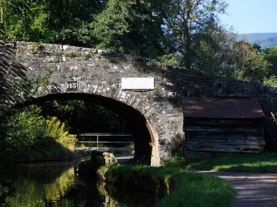 an old stone bridge over a river with a building at 3 Bed in Brecon oc-88249 in Brecon