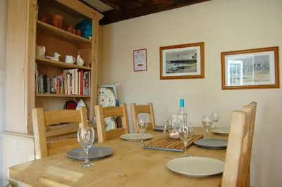 a dining room table with chairs and wine glasses at Glyn Saron near Tywyn in Bryn-crug