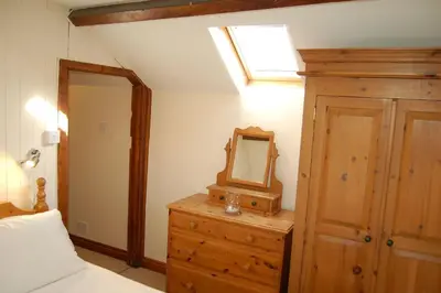 a bedroom with a mirror on top of a dresser at Glyn Saron near Tywyn in Bryn-crug