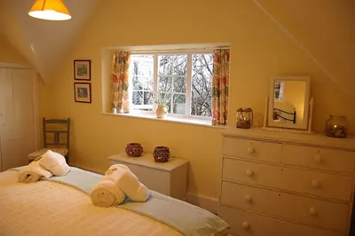 two beds in a bedroom with a window and a dresser at Minafon near Barmouth in Llanaber