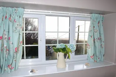 a window with a vase of flowers on a window sill at Minafon near Barmouth in Llanaber