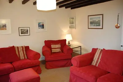 a living room with two chairs and a red couch at Minafon near Barmouth in Llanaber