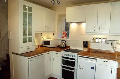a kitchen with white cabinets and a stove top oven at Minafon near Barmouth in Llanaber