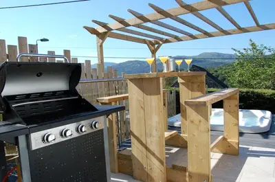 a outdoor kitchen with a grill and a pergola at Paradwys in Dolgellau in Dolgellau