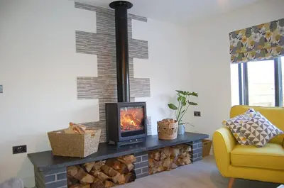 a fireplace in a living room with a stove at Paradwys in Dolgellau in Dolgellau