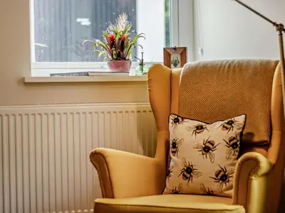 a chair with a pillow on it with a window at 6 Bed in Brecon oc-bn171 in Llanspyddid