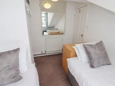 two beds in a small room with a mirror at No 9 On The Riverbank in Llangollen
