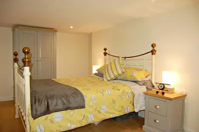 a bedroom with a bed with a yellow comforter at Sand Dune Apartment in Barmouth in Barmouth