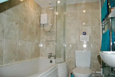 a bathroom with a tub and a toilet and a sink at Sand Dune Apartment in Barmouth in Barmouth
