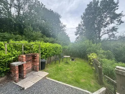 a small garden with a brick wall and grass at 1 Bed in Llanidloes oc-56492 in Van