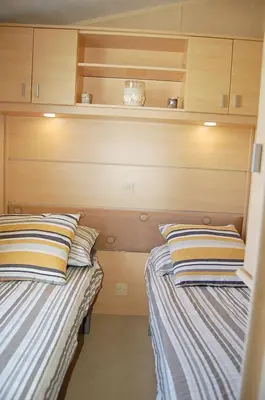 two beds sitting next to each other in a room at Caravan 251 Bryn Y Mor Beach Side Park in Tywyn