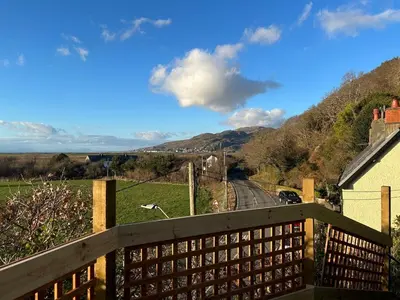 a view from the balcony of a house with a train tracks at South View Cottage with Terrace and Coastal Views in Fairbourne