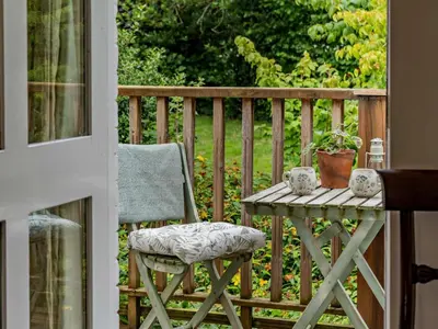 a table and a chair on a porch with a table and a table at 1 Bed in Brecon oc-bn157 in Llangorse