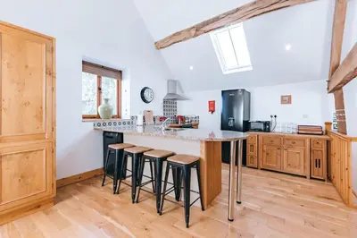 a kitchen with a large island with bar stools at ryton grange hay barn sleeps 6 in Shrewsbury