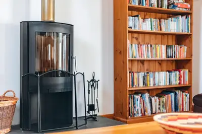 a black refrigerator in front of a book shelf at ryton grange hay barn sleeps 6 in Shrewsbury