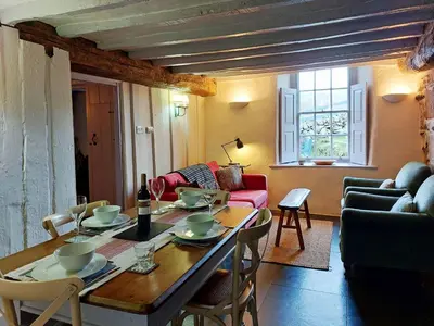 a living room with a table with chairs and a couch at CaeEinion Cottage a Georgeous Rural Retreat Nr Dolgellau in Dolgellau