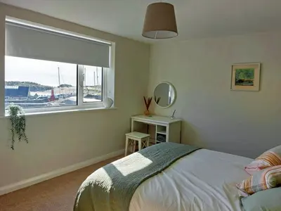 a bedroom with a bed and a window and a table at Craig View Fishermans Cottage nr Harbour and Beach in Barmouth