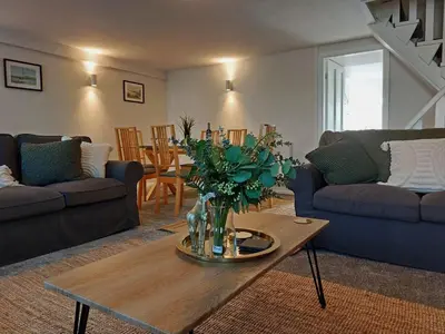 a living room with a vase of flowers on a table at Craig View Fishermans Cottage nr Harbour and Beach in Barmouth