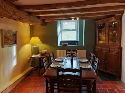 a dining room with a wooden table and chairs at Gallestra a Rustic, Rural Retreat Farm House Nr Dolgellau Snowdonia in Dolgellau