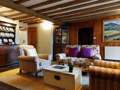 a living room with couches and a table at Gallestra a Rustic, Rural Retreat Farm House Nr Dolgellau Snowdonia in Dolgellau