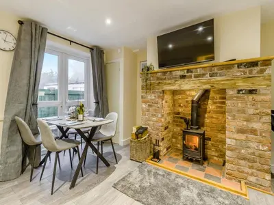 a dining room with a table and a stone fireplace at Brewers Cottage-Uk45454 in Montgomery