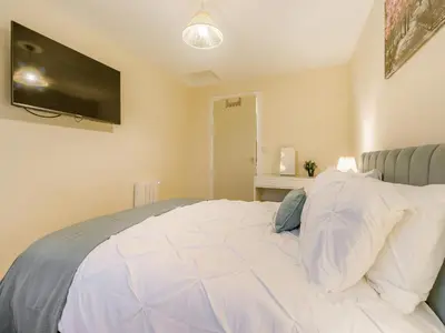 a bedroom with a white bed with a television on the wall at Brewers Cottage-Uk45454 in Montgomery